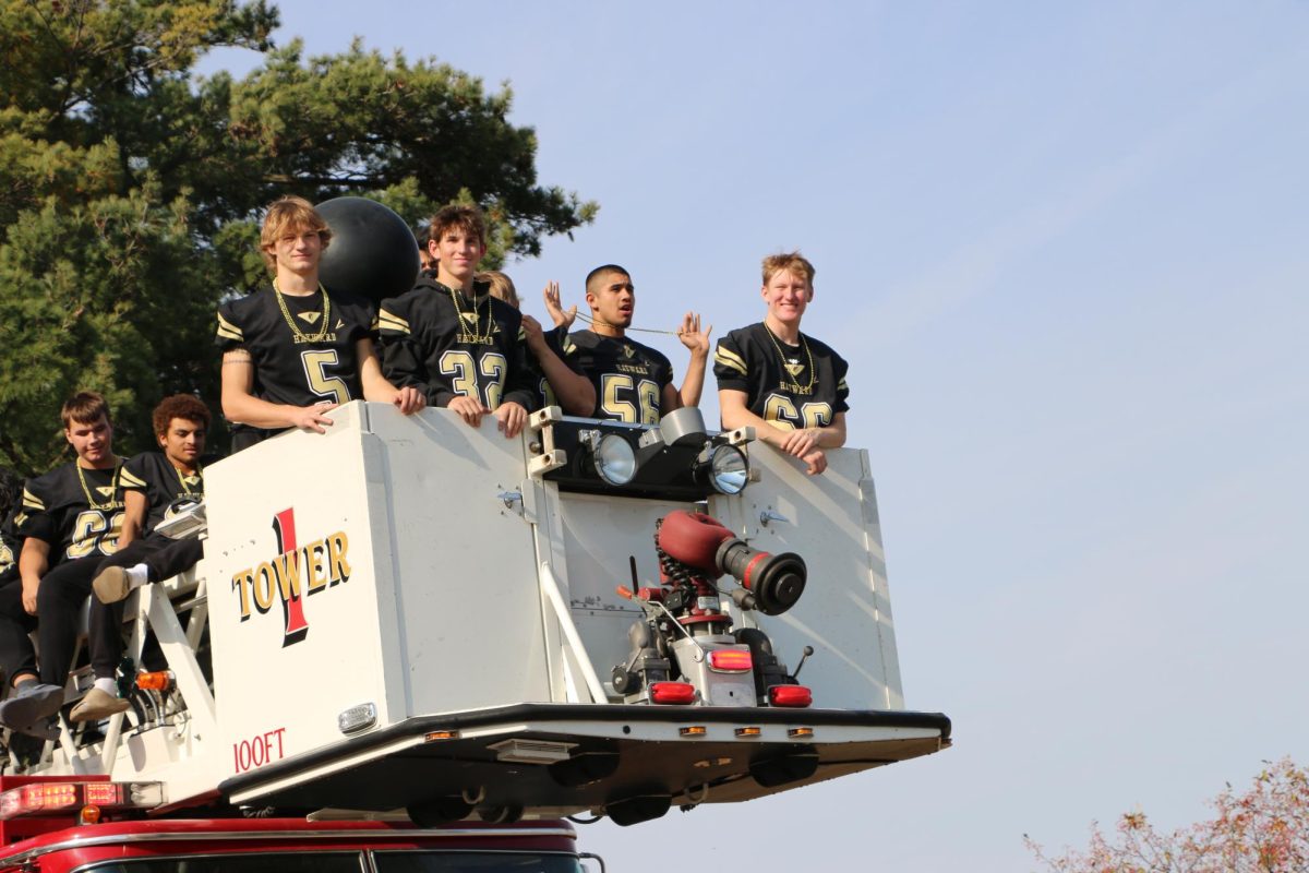 Football players ride the float through the Homecoming parade. 